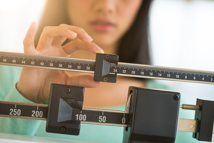 Midsection Of Woman Adjusting Weight Scale Semaglutide Weight Loss Program in Phoenix, AZ